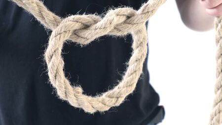 Person male hands tie a bowline knot in a piece of ropeの写真素材