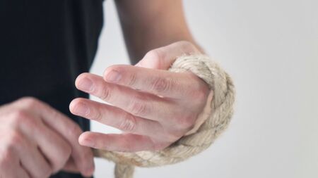 Man winding rope on his hand in black T-shirt