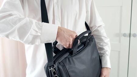 Person taking out things laptop of black bag.の写真素材