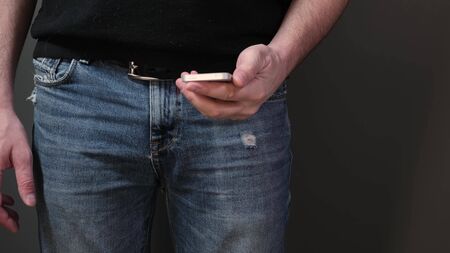Closeup view of hand pull out a smart phone of rear jeans pocket. Close upの写真素材