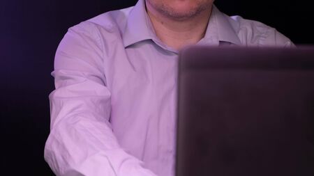 Man using, working on laptop with blank screen in home living room.