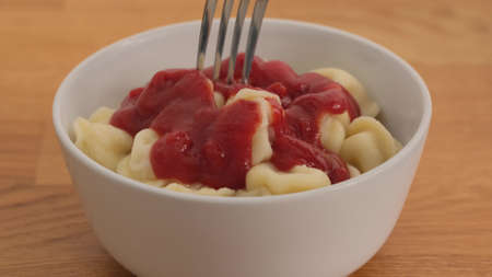 Man eating dumplings with ketchup a fork. Close upの写真素材