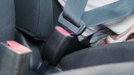 Male hand fastening car safety seat belt before driving