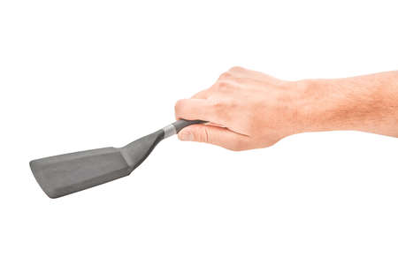 Male hands holding a spatula for frying. Isolated on gray background.の写真素材