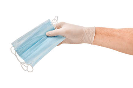 Doctors male hands in medical gloves holding a medical mask isolated whiteの写真素材