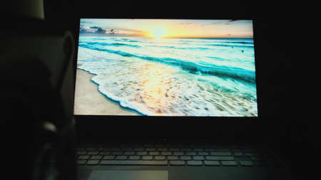 Young programmer student run assignment with laptop alone at midnight in the dark room. close upの写真素材