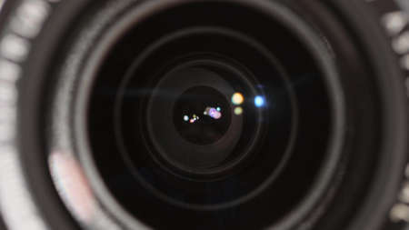 Photograph adjusting the aperture of his professional photo camera before taking pictures closeup....