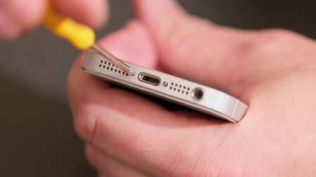 A smartphone with a green screen for your content. Telephone and wood screws on a wooden table. close upの写真素材