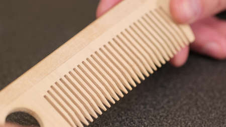 Thin comb of light wood on a white background. close upの写真素材