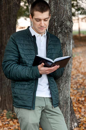 Man reading a book in city park outdoorの写真素材