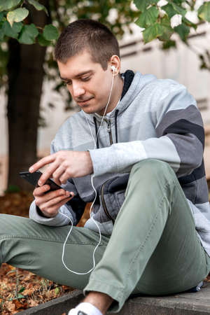 Young attractive man with headphones over urban backgroundの写真素材