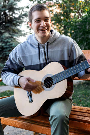 guy plays guitar in city park outdoorの写真素材