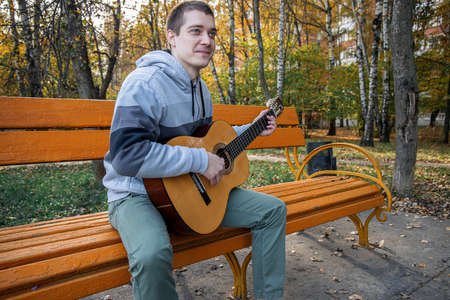 guy plays guitar in city park outdoorの写真素材