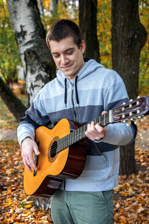 guy plays guitar in city park outdoorの写真素材