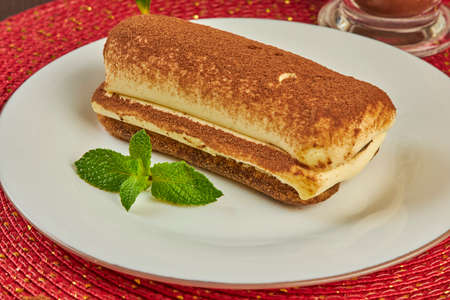 Piece of sponge cake and a cup of hot coffee on tableの写真素材