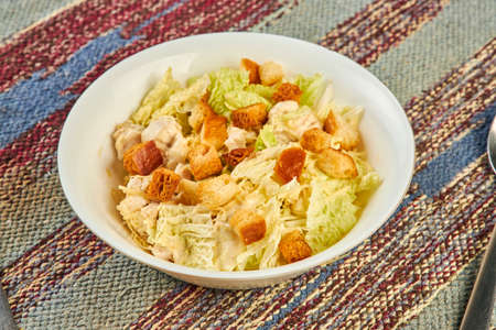 Closeup of fresh salad with croutons on table in cafeの写真素材