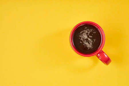 Top view image of red coffe cup on yellow background. Flat lay. Copy spaceの写真素材