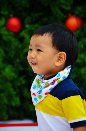 little boy stand infront of christmas treeのeditorial素材