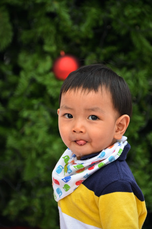 little boy stand in front of christmas treeのeditorial素材