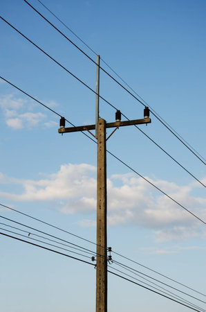 electrical post by the road against blue skyの写真素材