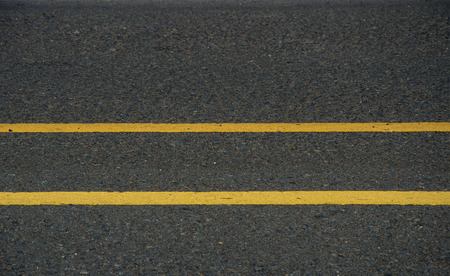 Asphalt dark texture background with double yellow linesの写真素材
