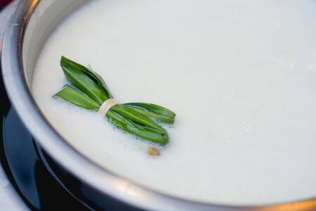 boil milk with pandan leaf in potの写真素材