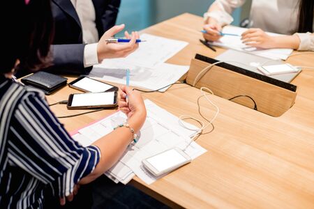 Business people working on laptop computer and phone in meeting room