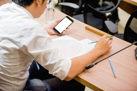 Business people working on laptop computer and phone in meeting room