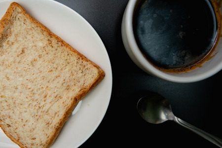 hot coffee and whole wheat bread on black backgroundの写真素材