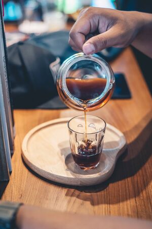 drip coffee glass teapot on hand pouringの写真素材