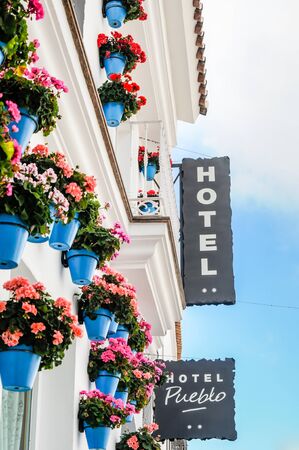 Benalmadena, Malaga Province, Andalusia, Spain - May 27, 2014: Facade of Hotel Pueblo in Benalmadena Pueblo. Typical Andalusian Hotel decorated with blue flower pots.のeditorial素材