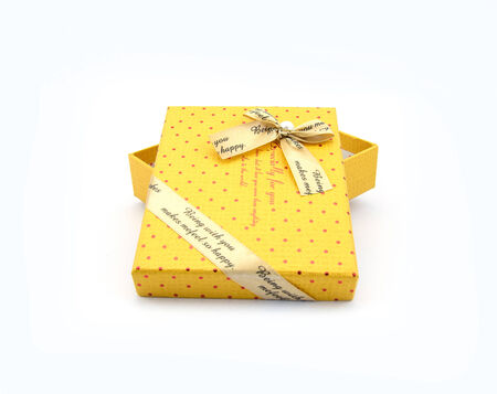 Yellow gift box and red pattern  with white knot is open uncoverの写真素材