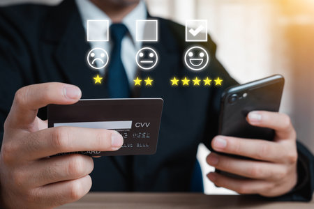 Men use their smartphones to rate customer service and satisfaction. Emoticons, happy smiley faces to provide satisfaction in service and rate of service rating. Buying products online Doing business.の写真素材