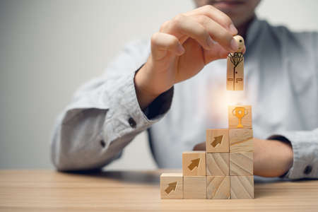 Handmade wooden doll is mean a virtual quality assurance famous and award-winning businessman, floating on top of a wooden cube for the future work, Concept a successful life.の写真素材