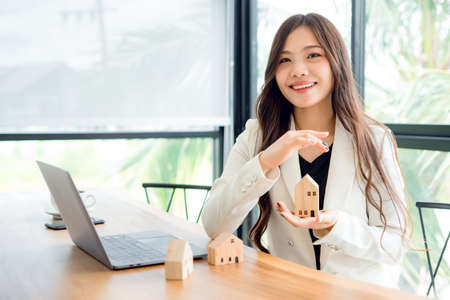 A woman real estate agent with a bright smile submits a professional offer to buy, sell or rent real...