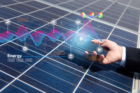 Engineer or electrician uses a smartphone to inspect or maintain a solar panel used in home or industry. The screen shows radiation temperature and hot quality of energy, renewable, green and clean.の写真素材