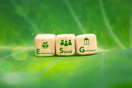 ESG, environment society and governance Wooden cubes on green leaves sustainability and ethics in...