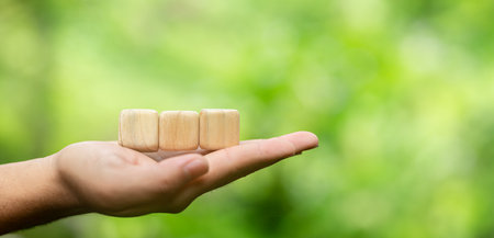 Wooden block stacking as step stair on blurred green nature background.の写真素材