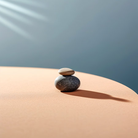 Balanced pebbles on sand with sunbeams and shadowsの素材