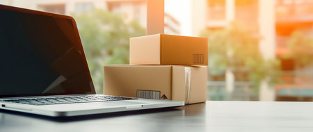 Boxes and laptop on the table in office, online shopping conceptの素材