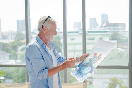 Elderly senior man in casual outfit art paint working with happy and focus emotion in modern room.
