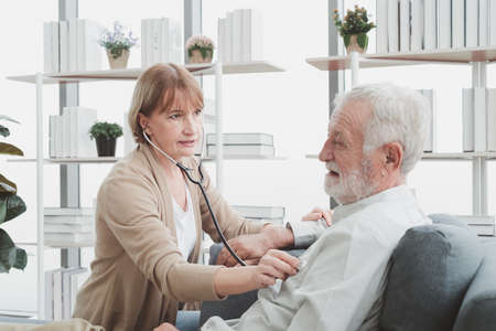 Senior elderly woman doctor sitting and health check with her patient.の写真素材