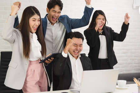 Business Asian people in formal outfit working together and being success and winning from company profit in office workplace room.の写真素材