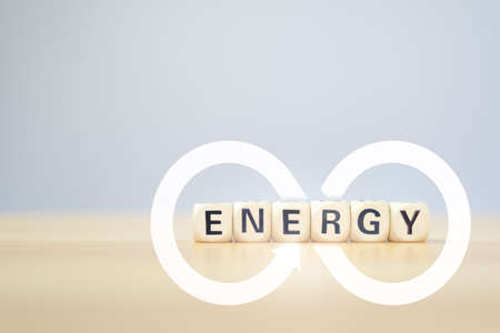 Renewable energy concept of infinity power wood cube with ENERGY word on wood table with clear...
