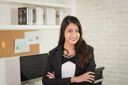 Portrait of business woman in formal outfit working with smile and confidence in modern workplace.