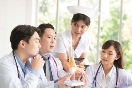 Group of Asian doctor in working uniform meeting and discuss with other colleagues in modern office...
