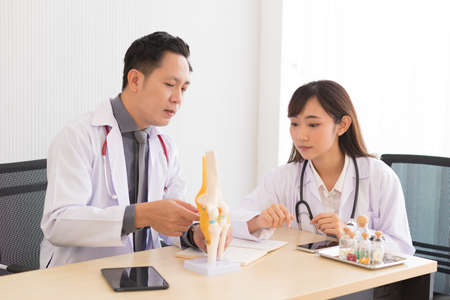 Group of Asian doctor in working uniform meeting and discuss with other colleagues in modern office clinic room.の写真素材