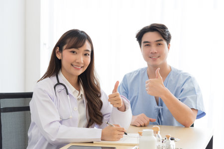 Asian doctor in professional work uniform discuss and explain symptoms to her patient.の写真素材