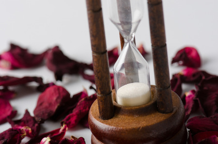 Dried rose petal with sandglass. Time is runing out.