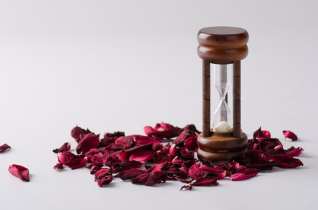 Dried rose petal with sandglass. Time is runing out.